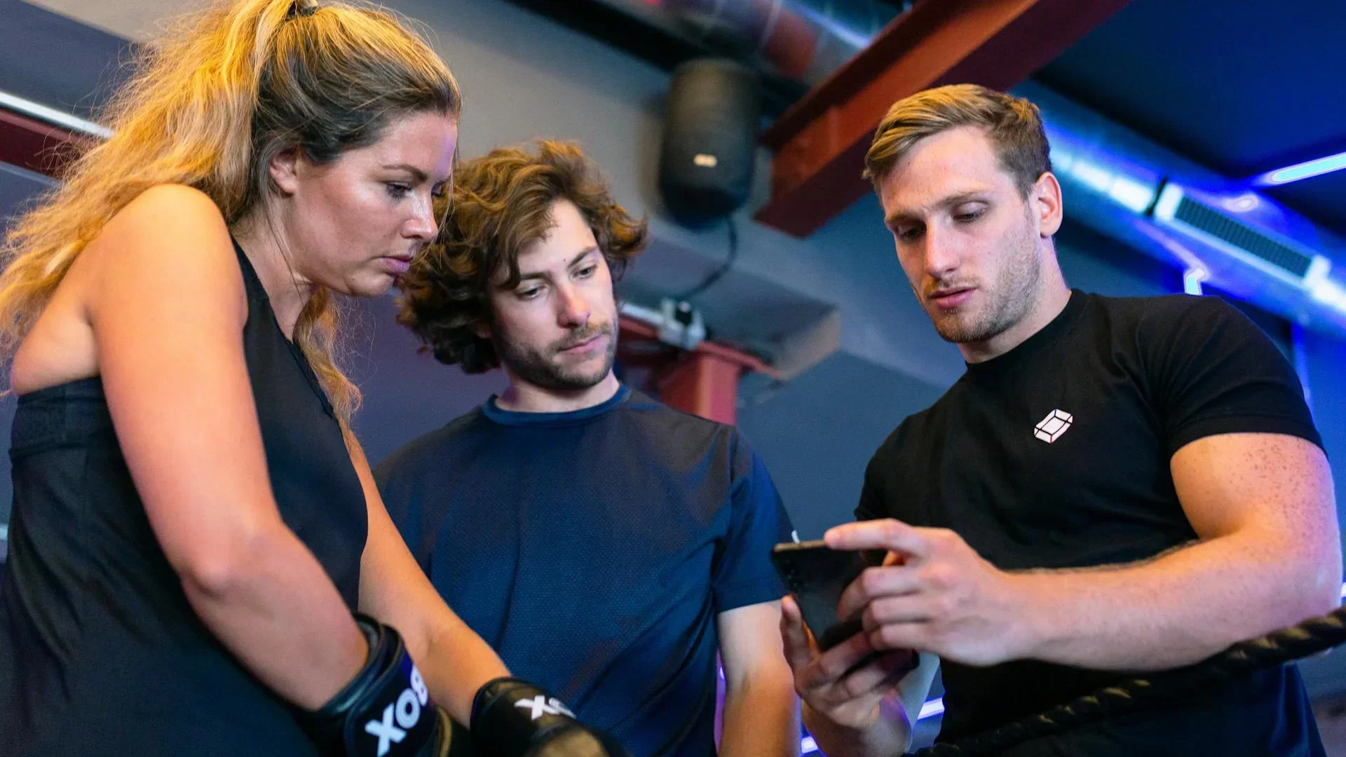 Personal trainer showing clients a scheduling app for booking fitness classes and 1-on-1 sessions.