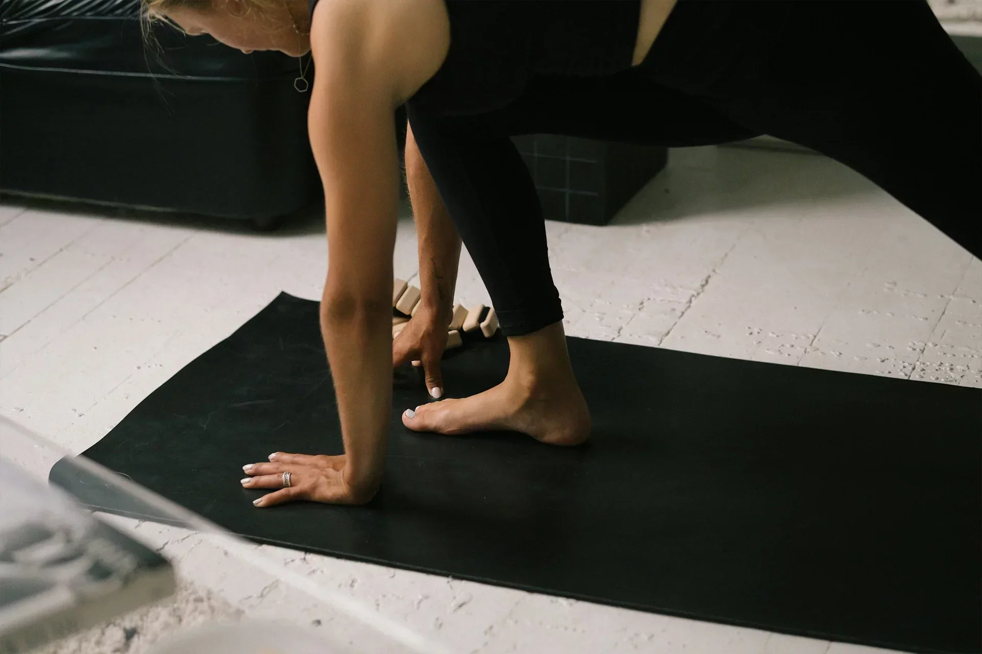 Woman practicing Pilates in the studio on a black mat—ideal setting for small studios using simple online booking software