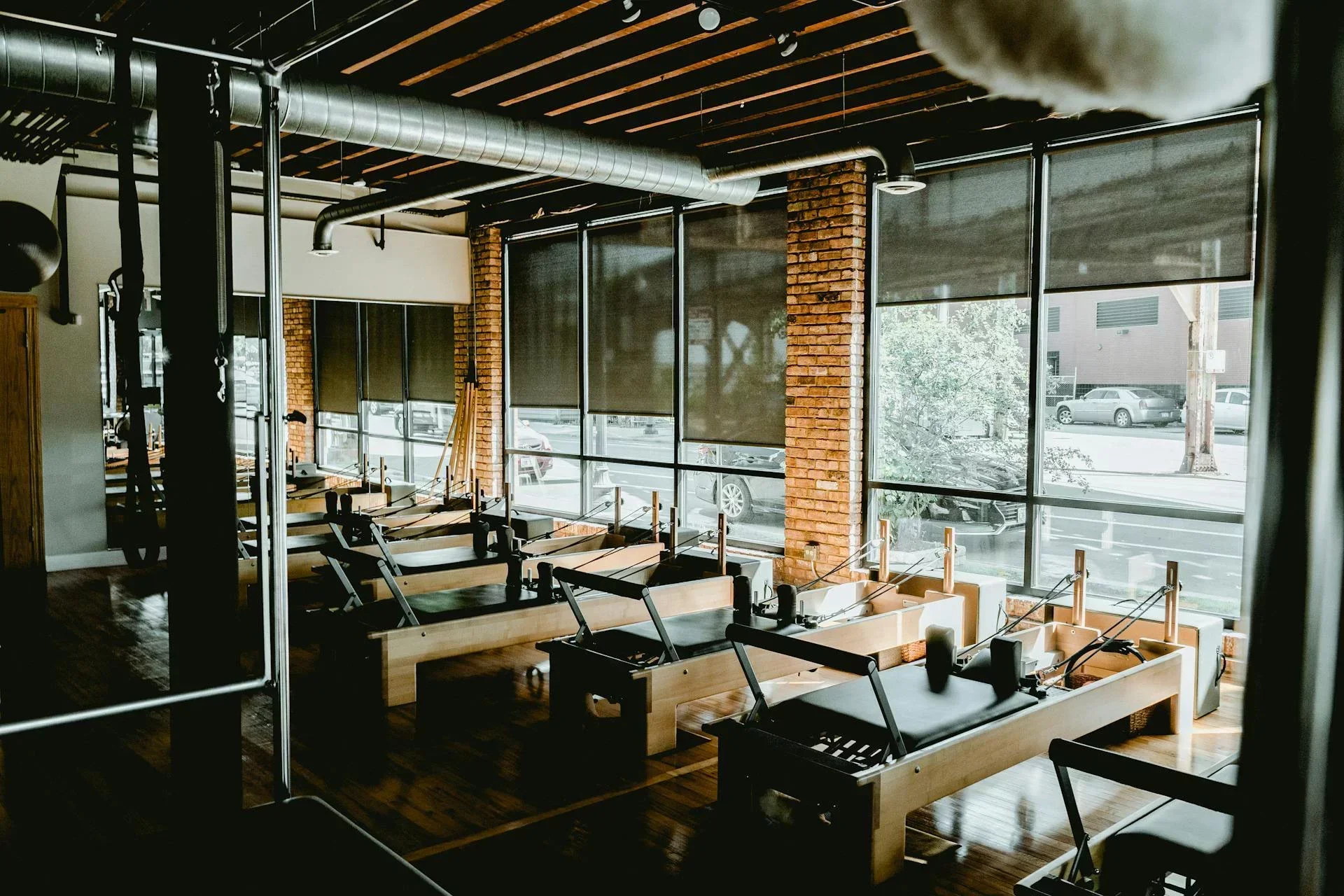 Modern Pilates studio with multiple reformer machines and natural light — ideal setup for beginner Pilates studios looking to create an online class schedule.