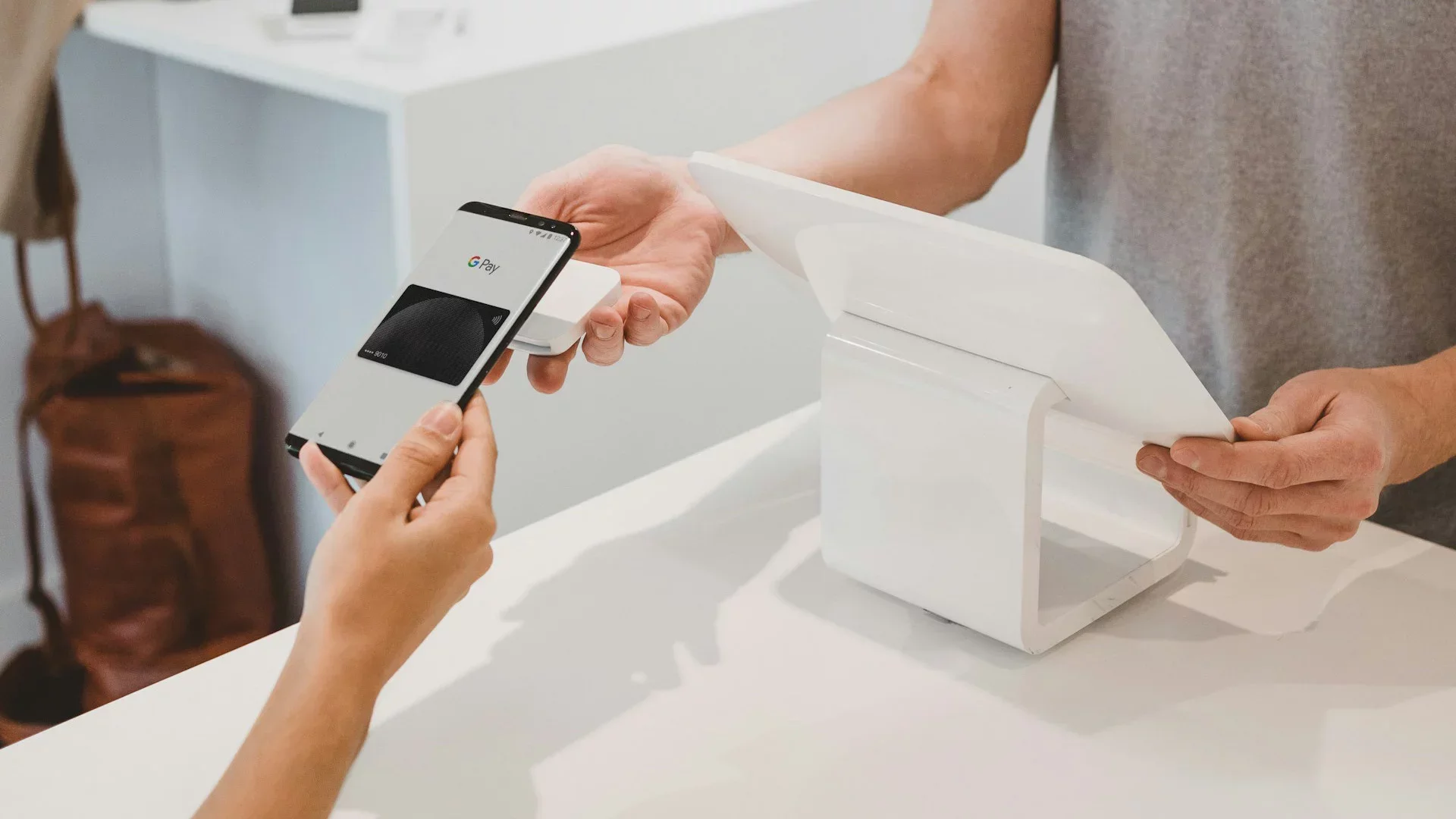Gym client using contactless payment via smartphone, highlighting seamless and automated transactions enabled by gym booking and payment software
