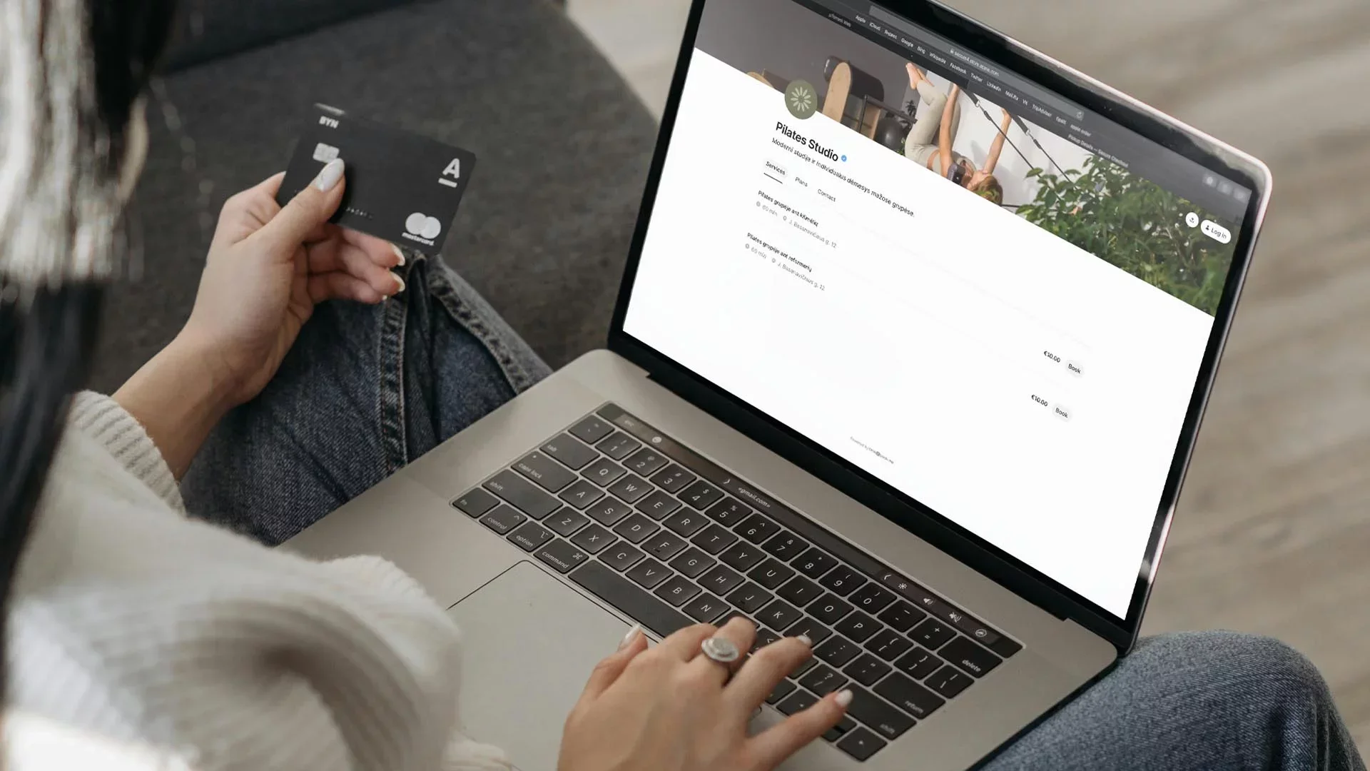 Client booking a Pilates class and paying online with a credit card using a fitness studio’s digital scheduling system on a laptop.